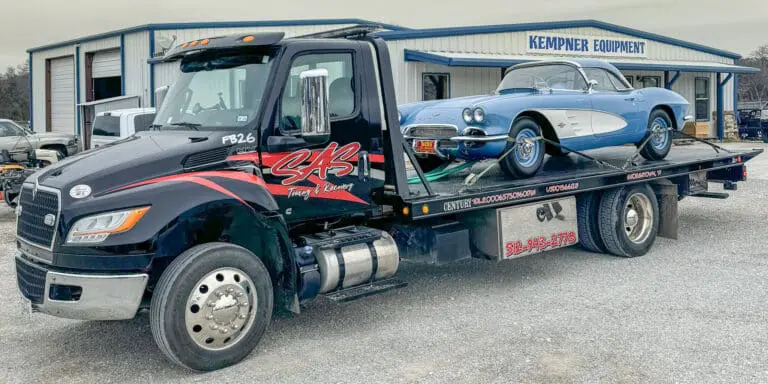 SAS Towing & Recovery flatbed tow truck transporting classic blue Corvette in Central Texas – professional 24/7 towing service.