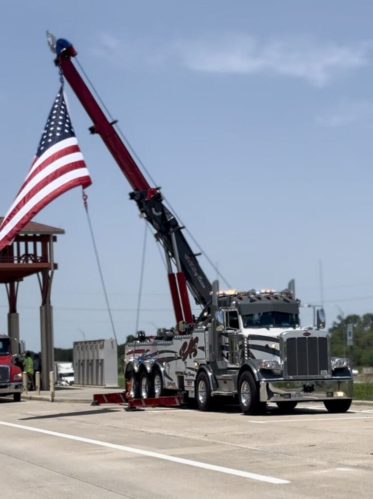 Crane vehicle use for towing heavy equipment with USA flag on it