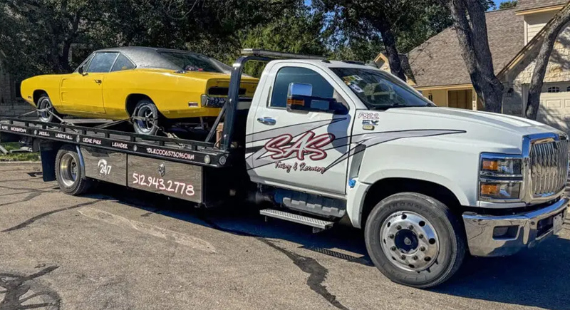 SAS Towing & Recovery flatbed truck transporting a vehicle for towing Taylor TX service